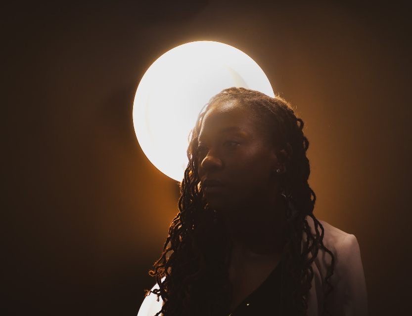 Tameka Hall lit from behind by a studio lamp